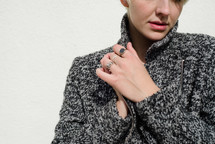 a female model in a sweater clasping her hands 