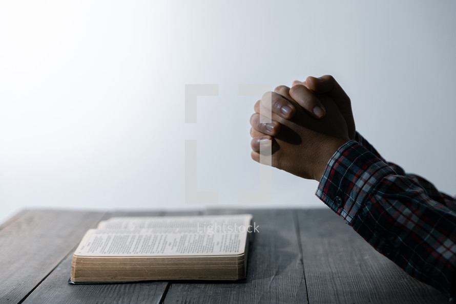 White background and praying hands and Bible