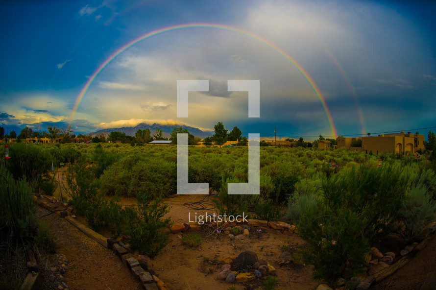 double rainbow over desert landscape 