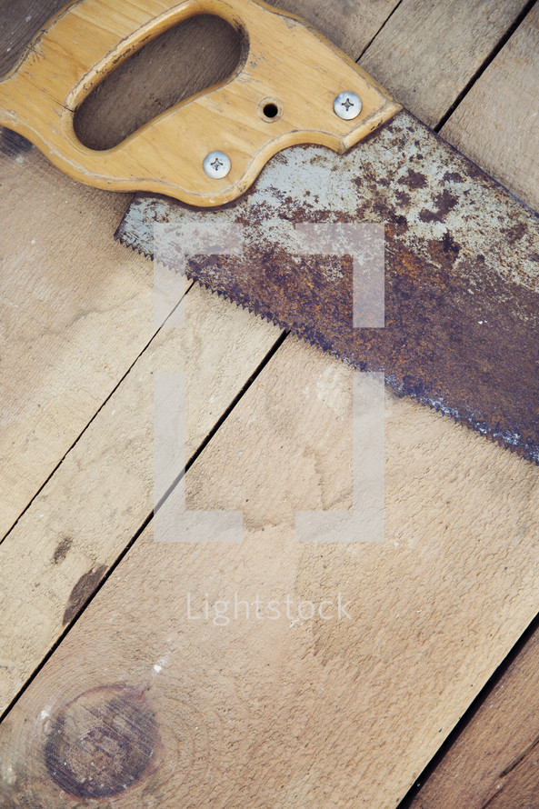 rusty saw on a wood floor 