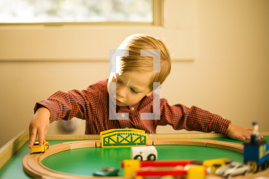 toddler boy playing with a toy train 