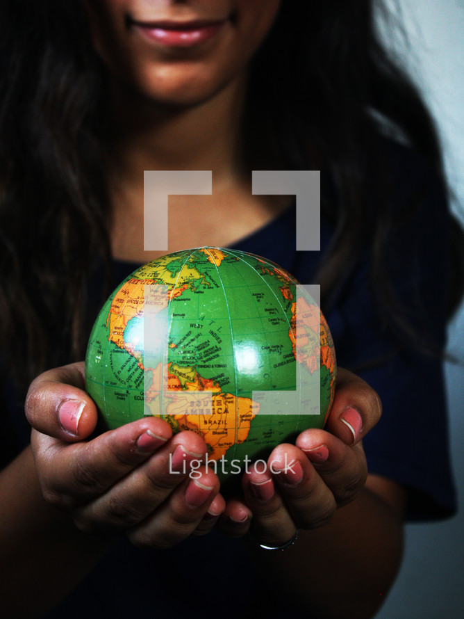 a girl holding a globe 