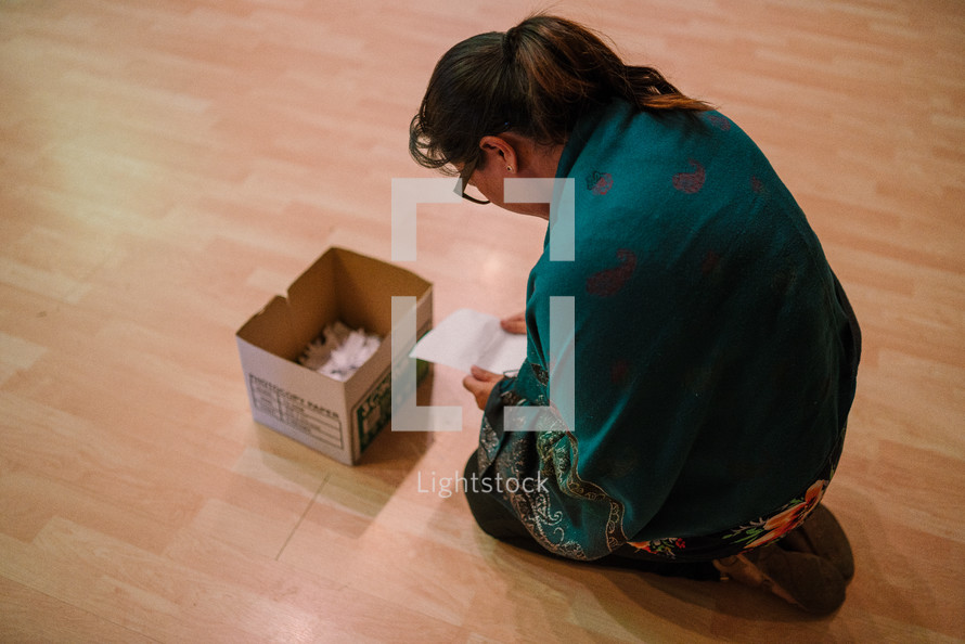 a woman placing her sins in a box during a worship service 