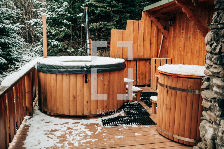 Open-air bath interior near forest, winter, snow view. Wooden hot tub outside. Recreation, spa procedures in steaming pool, private treatment. Thermal at snowy mountains.