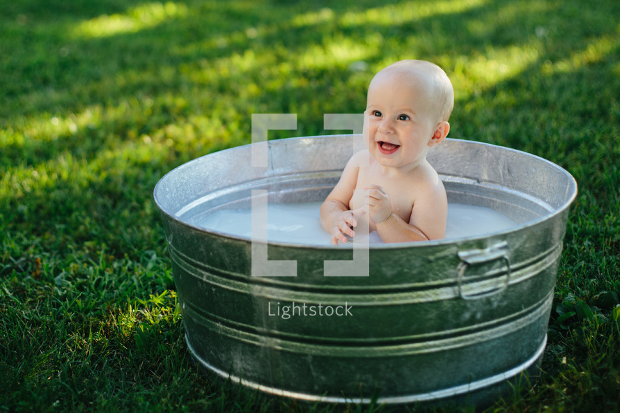 baby in a metal tub outdoors 