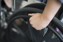 a hand on a wheelchair wheel 