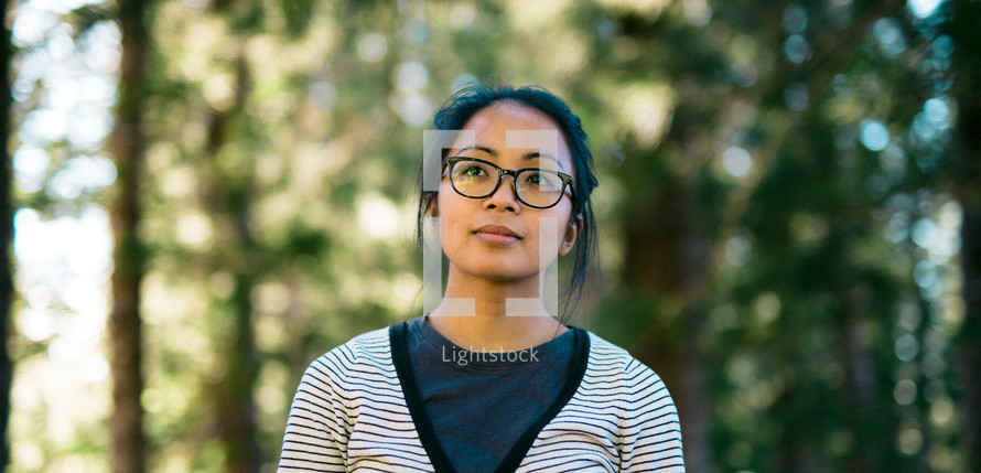 woman wearing glasses standing outdoors 