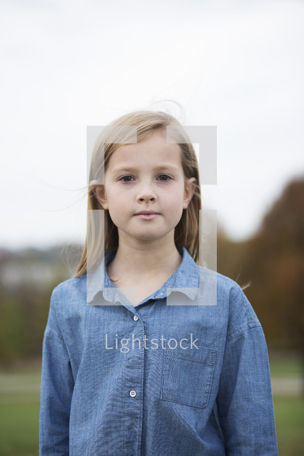 portrait of a young girl standing outdoors 