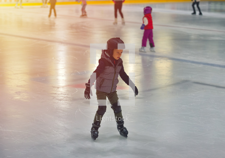 boy ice skating wearing a helmet 