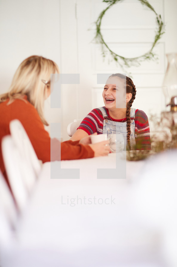 mother and daughter talking at the kitchen table 