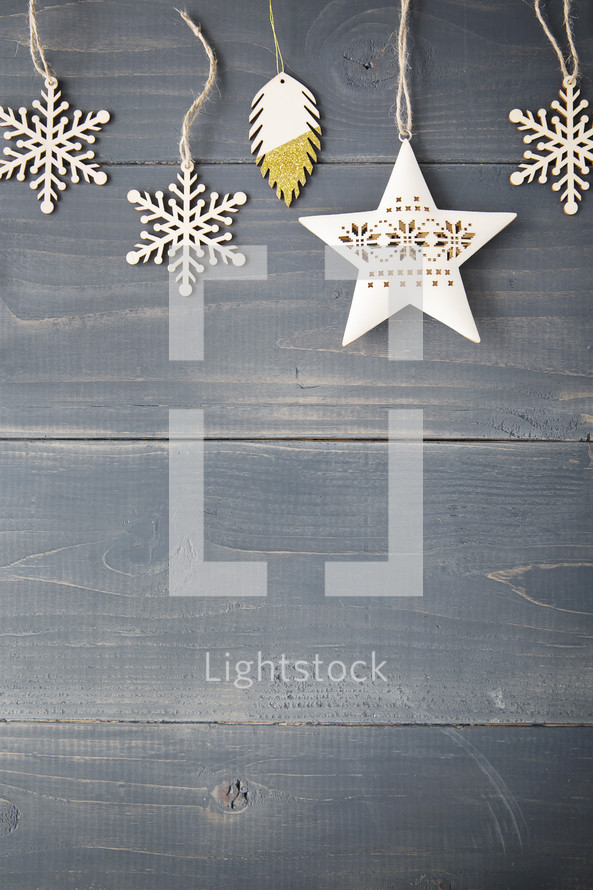 Snowflake and star ornaments on a wooden background.