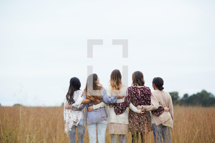 a group of young women standing in a field 