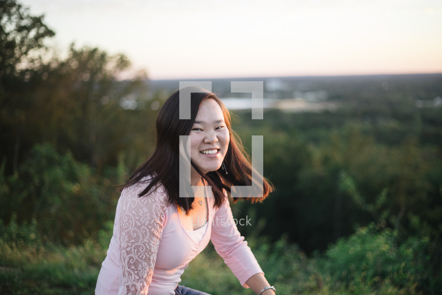 smiling woman outdoors at sunset 