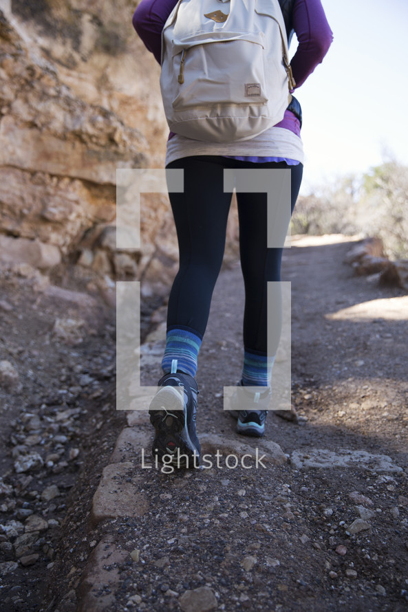 woman hiking up a mountain trail 