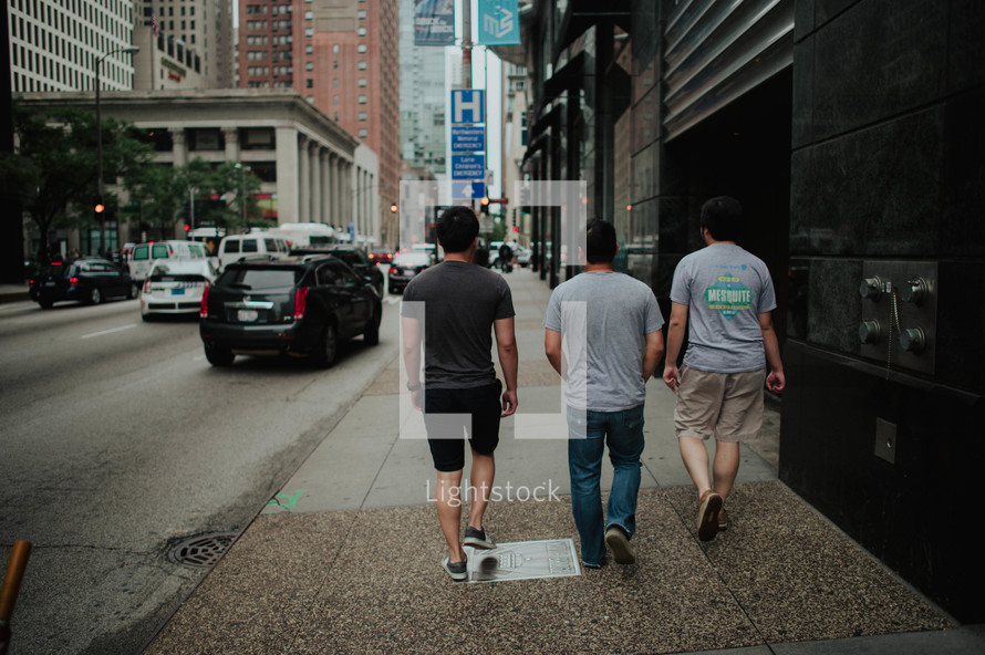 men walking down a city sidewalk 