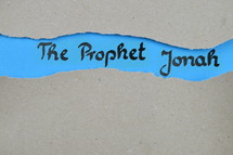 The Prophet Jonah - torn open kraft paper over blue paper with the name of the prophetic book Jonah