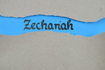 Zechariah - torn open kraft paper over blue paper with the name of the prophetic book Zechariah