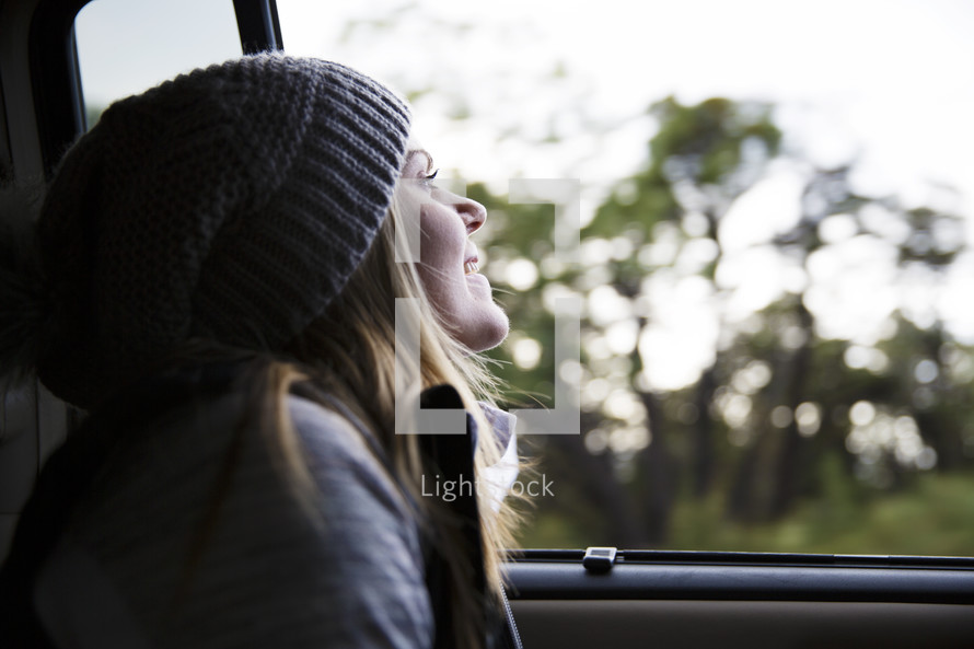 woman looking out a car window 