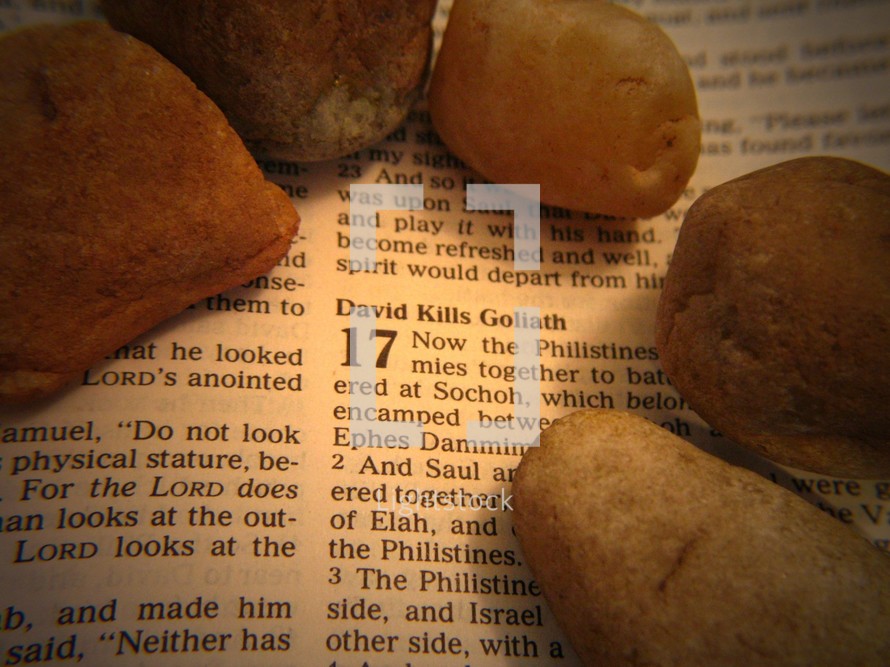 Stones laying on Bible open to Samuel 17.