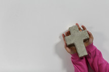 girl holding a stone cross