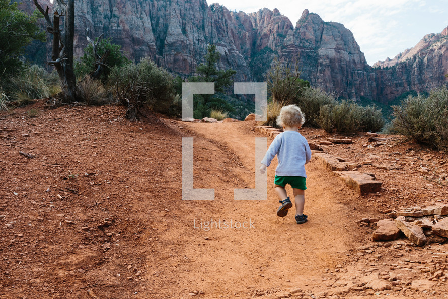 toddler boy exploring a desert path 