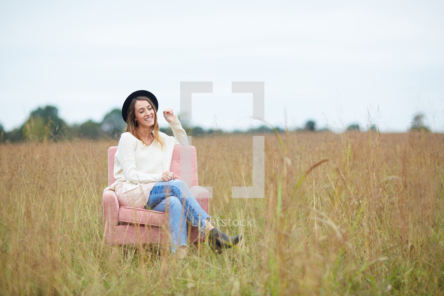 a woman sitting in a chair in a field 