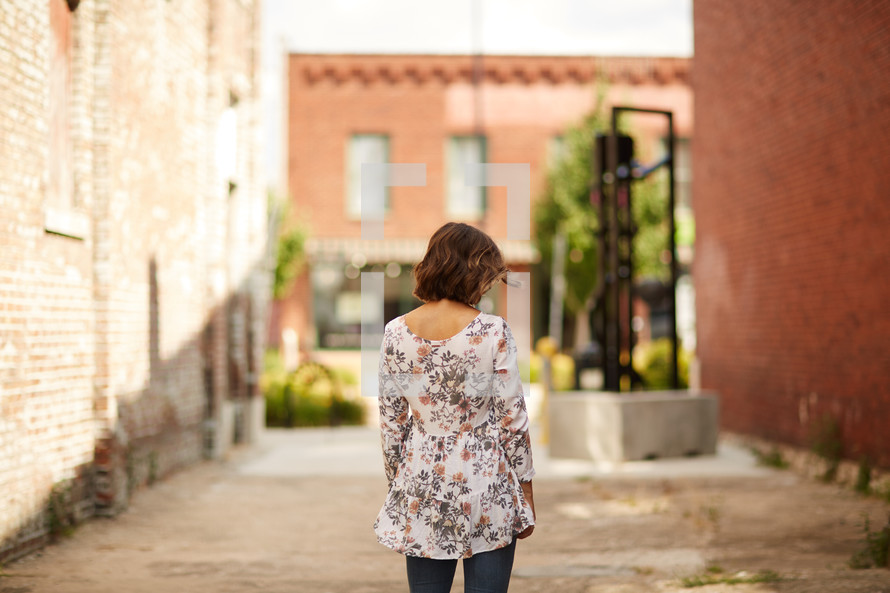 a woman walking in an alley 