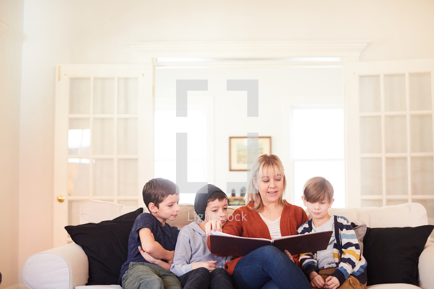 mother reading a book to children at Christmas 