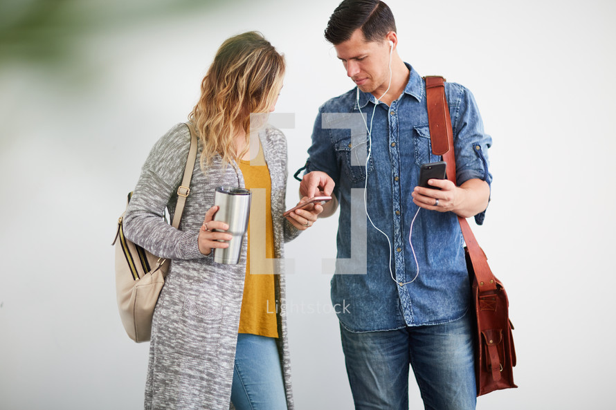 a man and woman standing listening to earbuds 