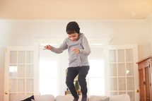 boy jumping on a couch 