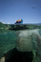 Snorkeler with head above water in ocean.