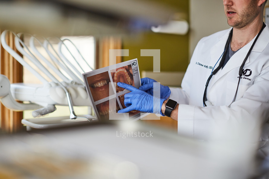 a dentist looking at digital scans and talking to his patient 