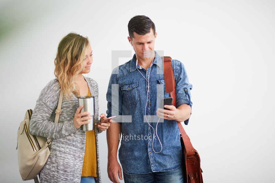 a man and woman standing listening to earbuds 