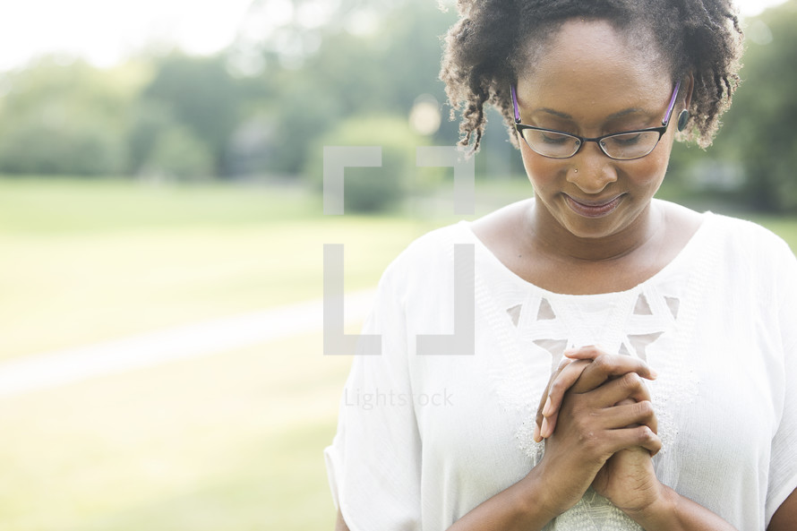 African-American woman with head bowed in prayers 