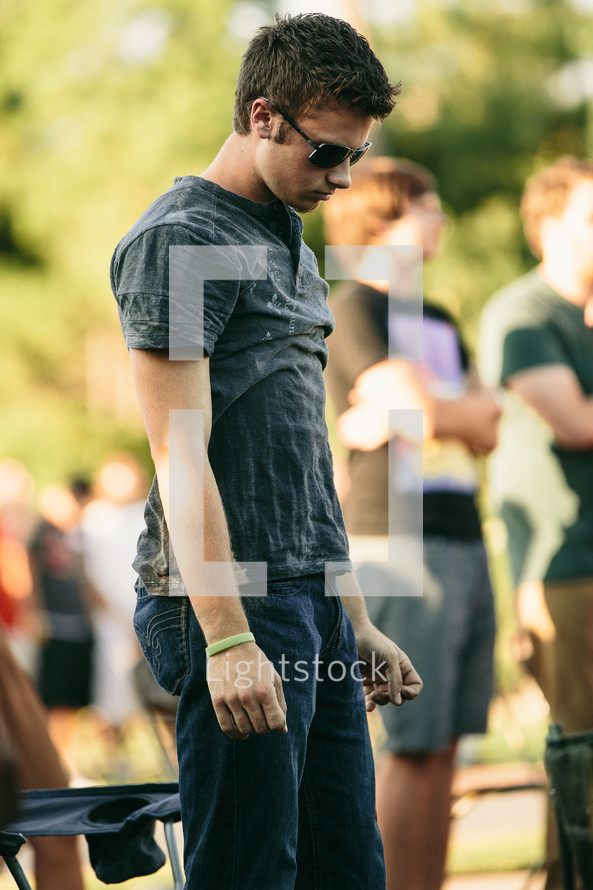 young man in sunglasses at an outdoor concert 