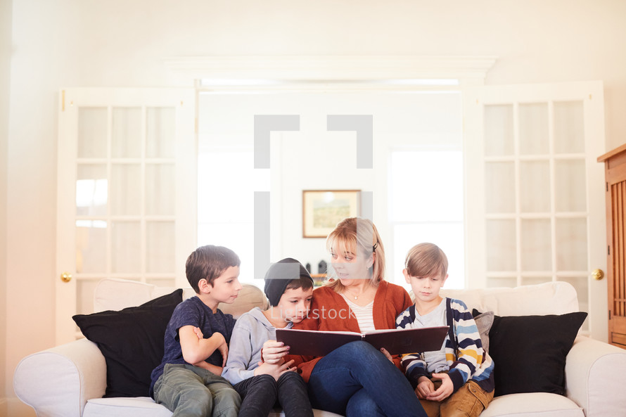 mother reading a book to children at Christmas 