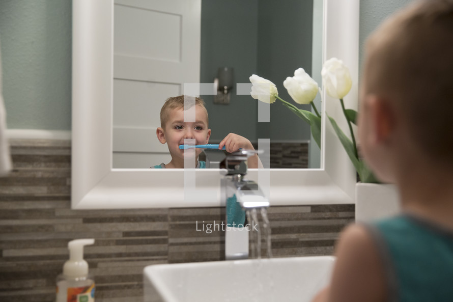child brushing his teeth at the sink 