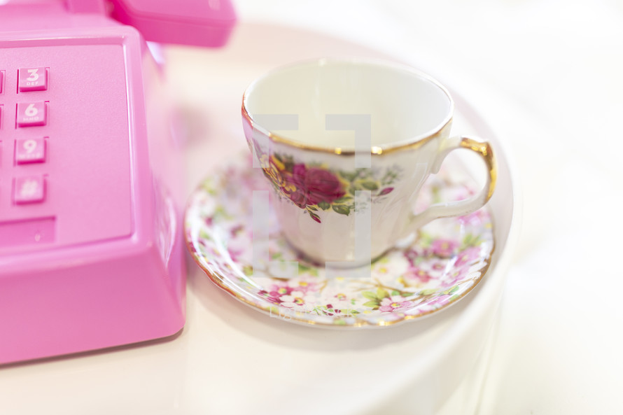 pink rotary telephone and tea cup 