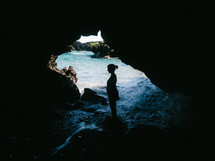 silhouette of a woman standing in a sea cave