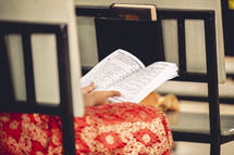 Person reading the Bible at a church in India.