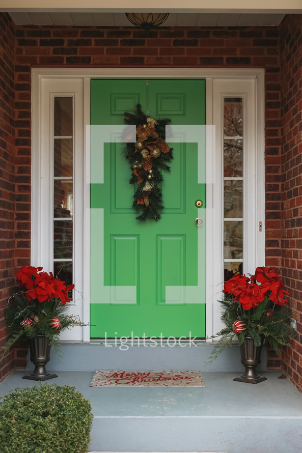 Christmas decorations on porch with green door