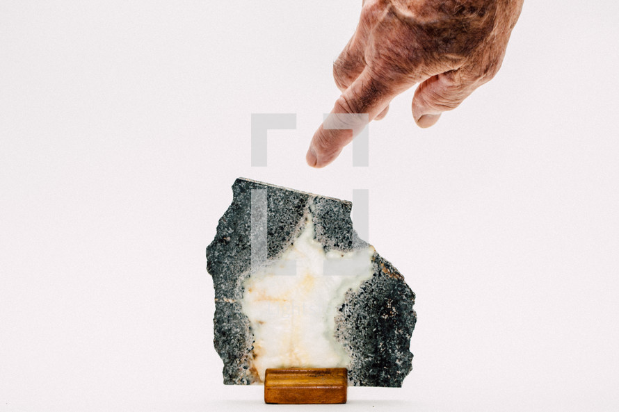 man pointing to a rock 