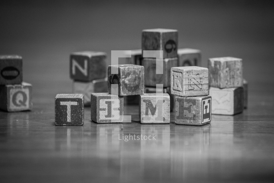 pile of wood blocks on a playroom floor and the word time 