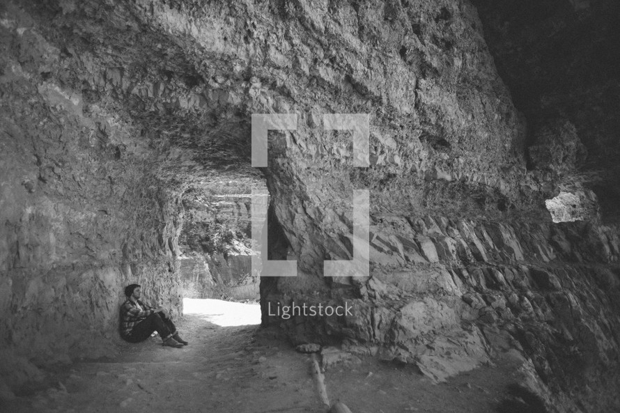 Man sitting in a cavern.