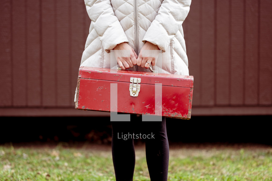 a woman holding a toolbox