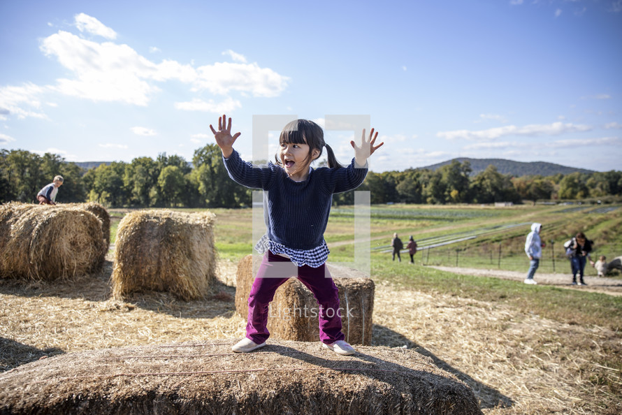 Little girls jumping on the hay