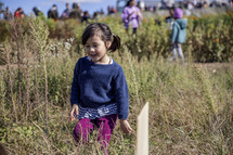 Little girl walking through tall grass