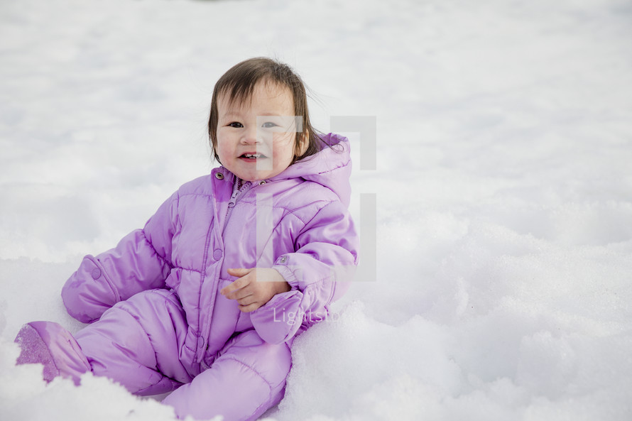 a baby playing in snow 