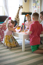 children coloring at a table with mom 
