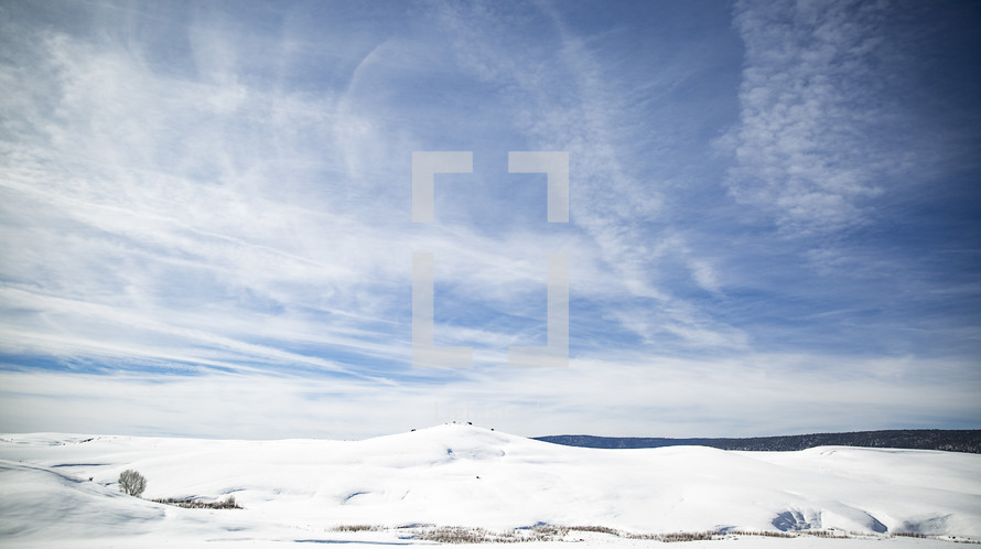 blue skies over snowy hills 